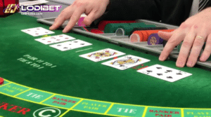 a casino dealer managing a baccarat game with different playing cards and casino chips